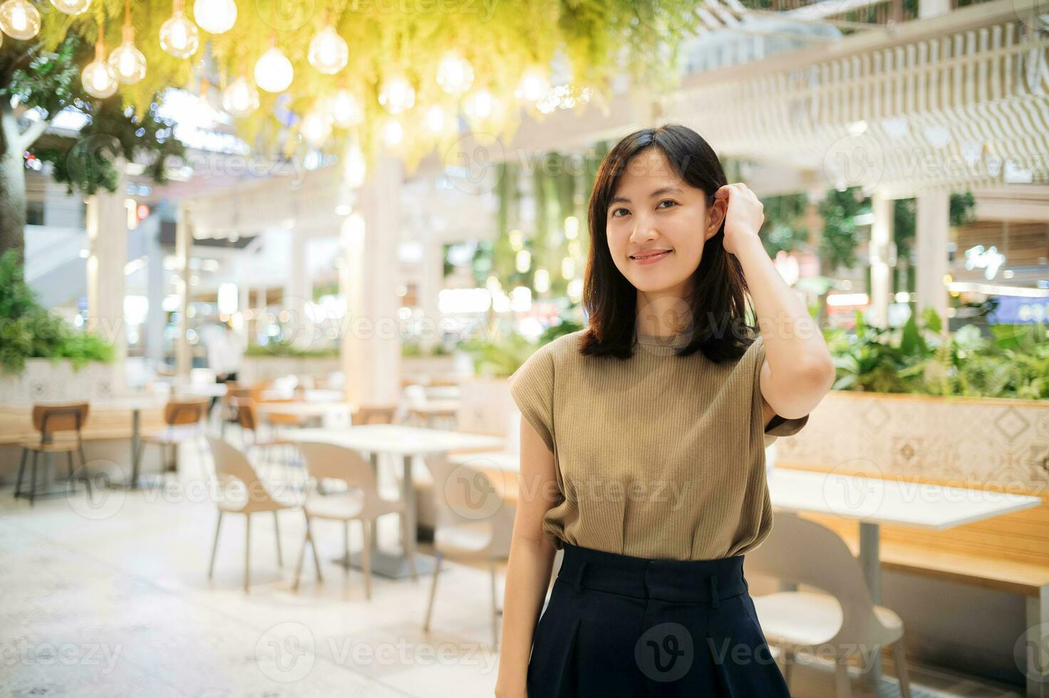lächelnd schön asiatisch Frau Stehen im Cafeteria beim Einkaufen Einkaufszentrum. foto