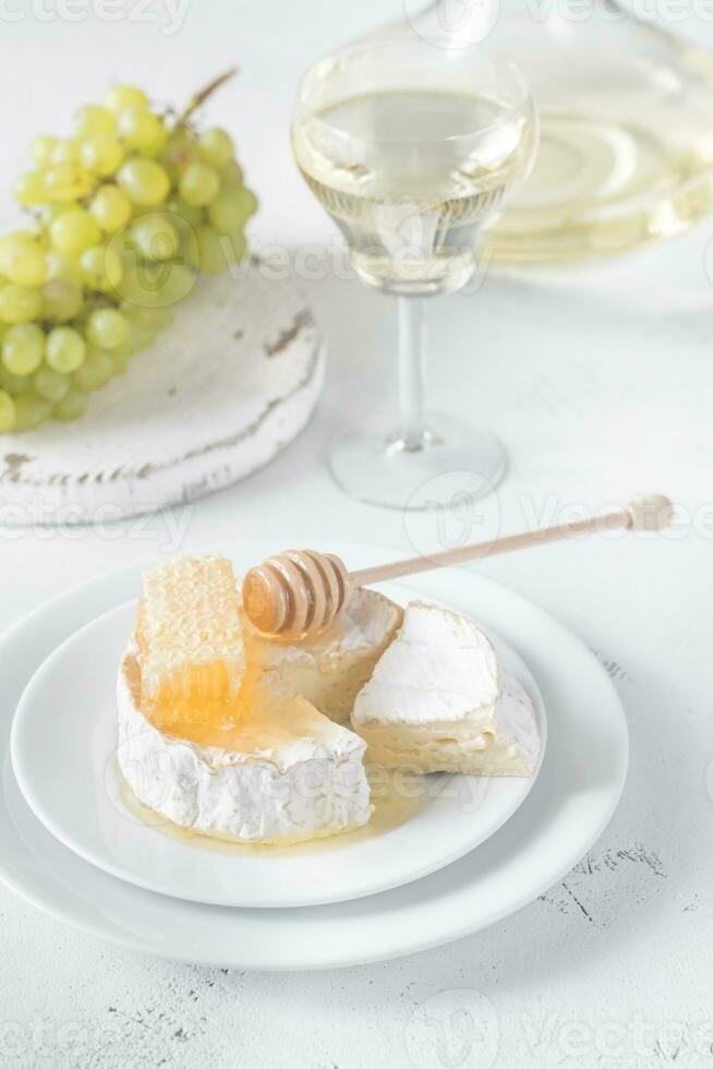 Camembert mit Honig, Trauben und Weiß Wein foto