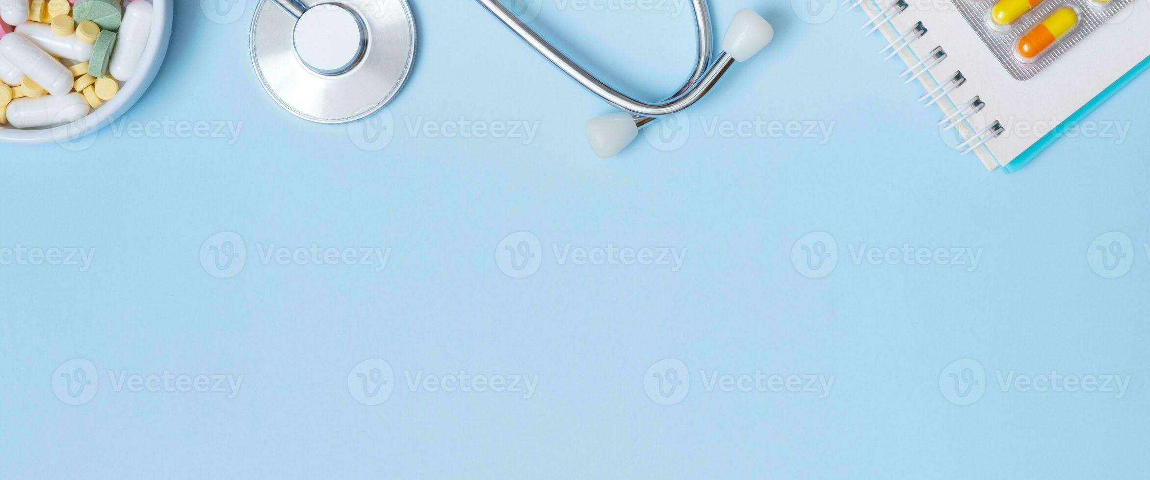 Fragment von Stethoskop, Notiz, Tabletten auf Blau Hintergrund mit Kopieren Raum. Gesundheitswesen und Medizin Banner eben legen, oben Aussicht foto