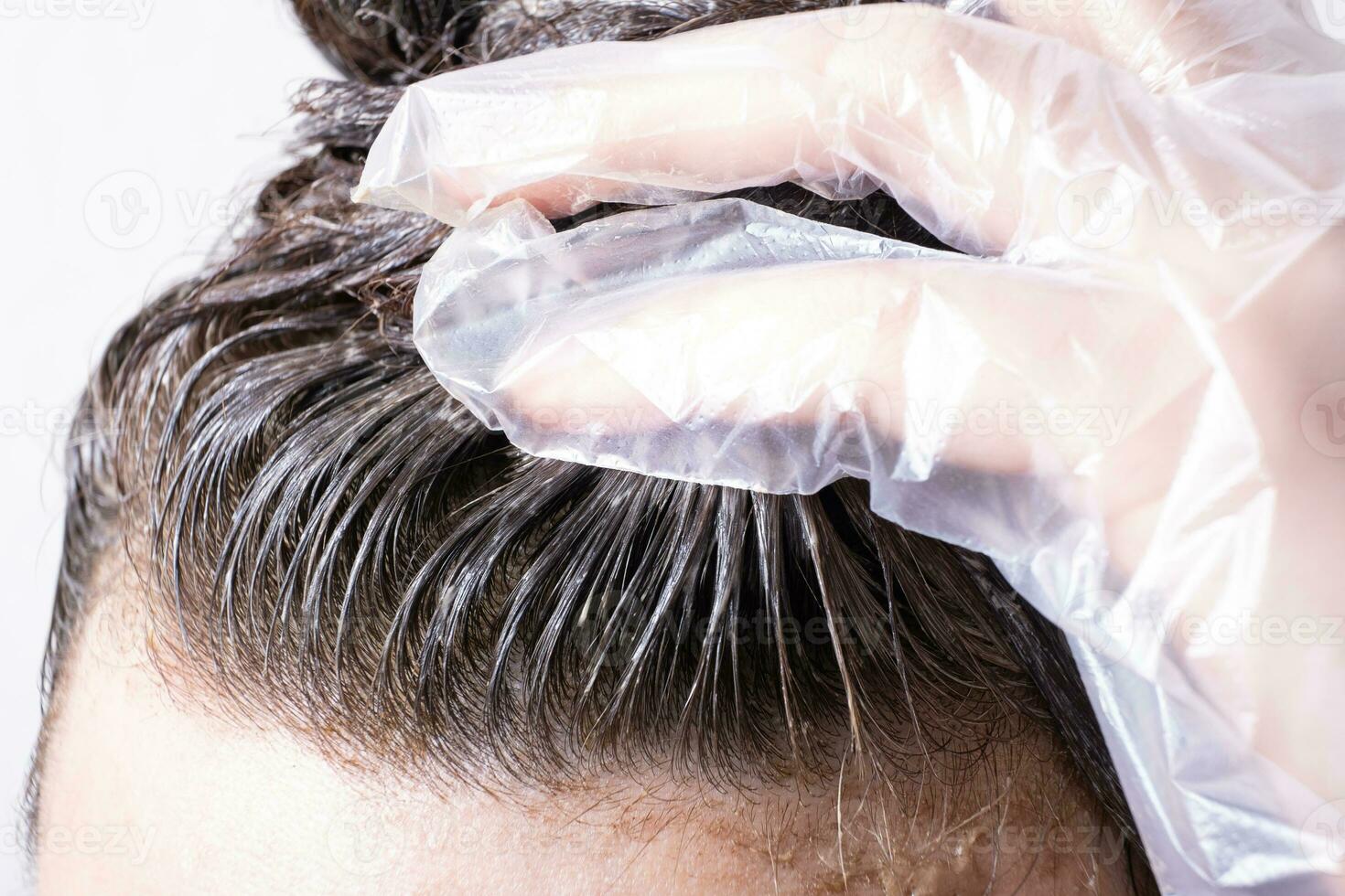 Damen Haar mit Farbe angewendet zu es und behandschuhte Hand. Haar Färberei Konzept foto