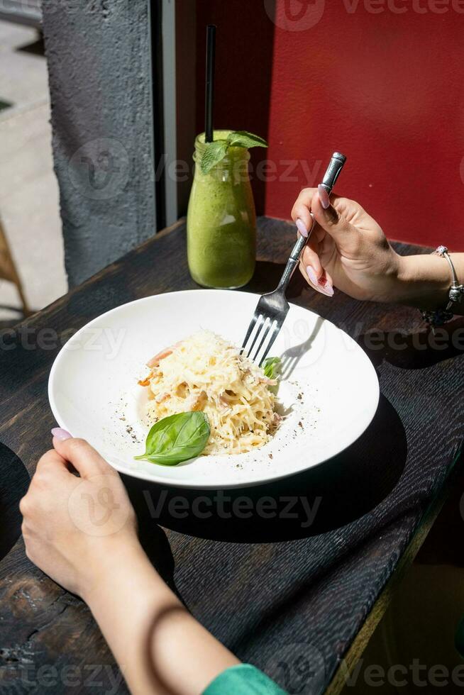 Frau Essen Italienisch Pasta Sitzung beim das Cafe Zähler suchen zu das Fenster, haben Mittagessen foto