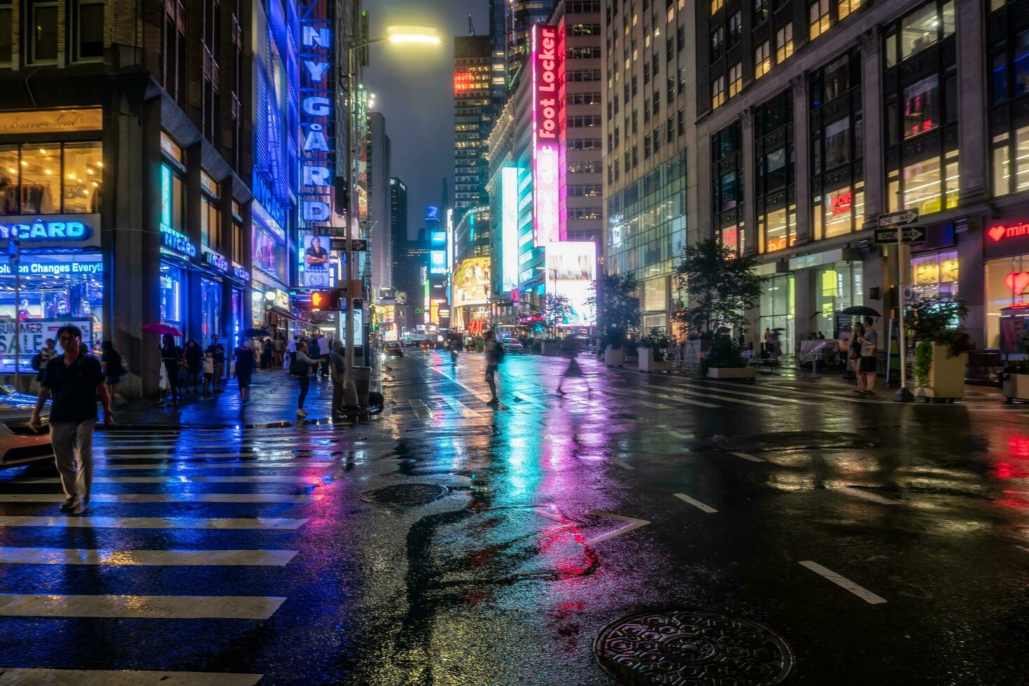 Neu York Stadt, USA - - August 9, 2019-Menschen und Touristen Bummel unter das Beleuchtung und Wolkenkratzer von Zeit Platz im Manhattan während ein Sommer- Nacht foto