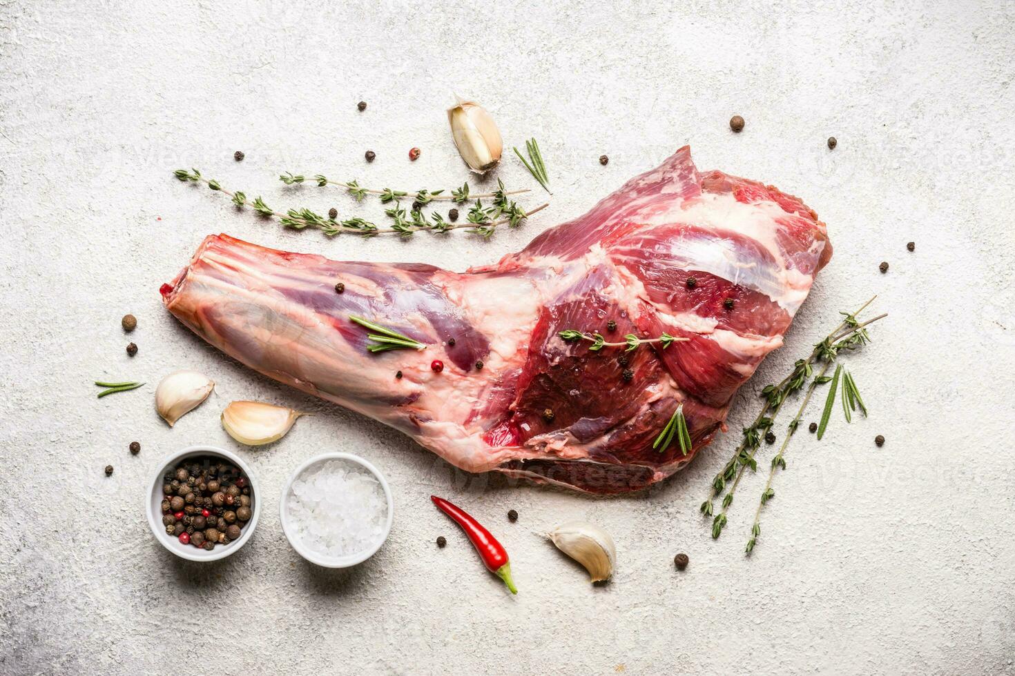 roh frisch Lamm Fleisch Schaft und Gewürze auf grau Beton Hintergrund foto