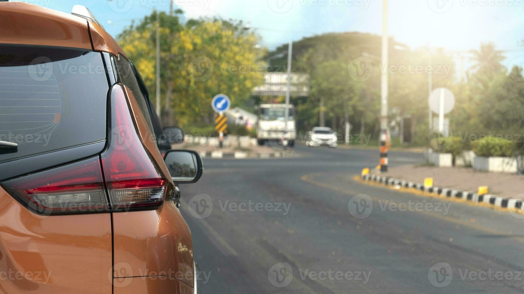 Rückseite Seite von Orange Wagen. schließen oben von Auto Schwanz Licht. halt auf das asphaltiert Straße. warten im Linie Nächster zu der Verkehr Beleuchtung. andere Autos über das Straße. foto