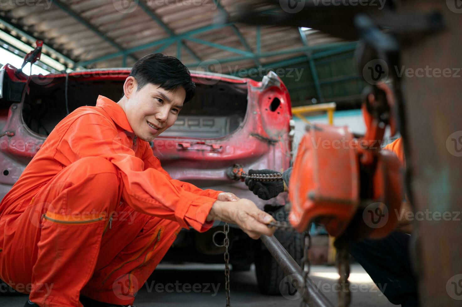 zu Rückkehr das Automobil Körper zu es ist ehemalige Form, ein Auto Reparatur Mechaniker Verwendet ein Maschine zu ziehen das Auto Körper verursacht durch ein schwer Kollision bis um es ist deformiert. foto