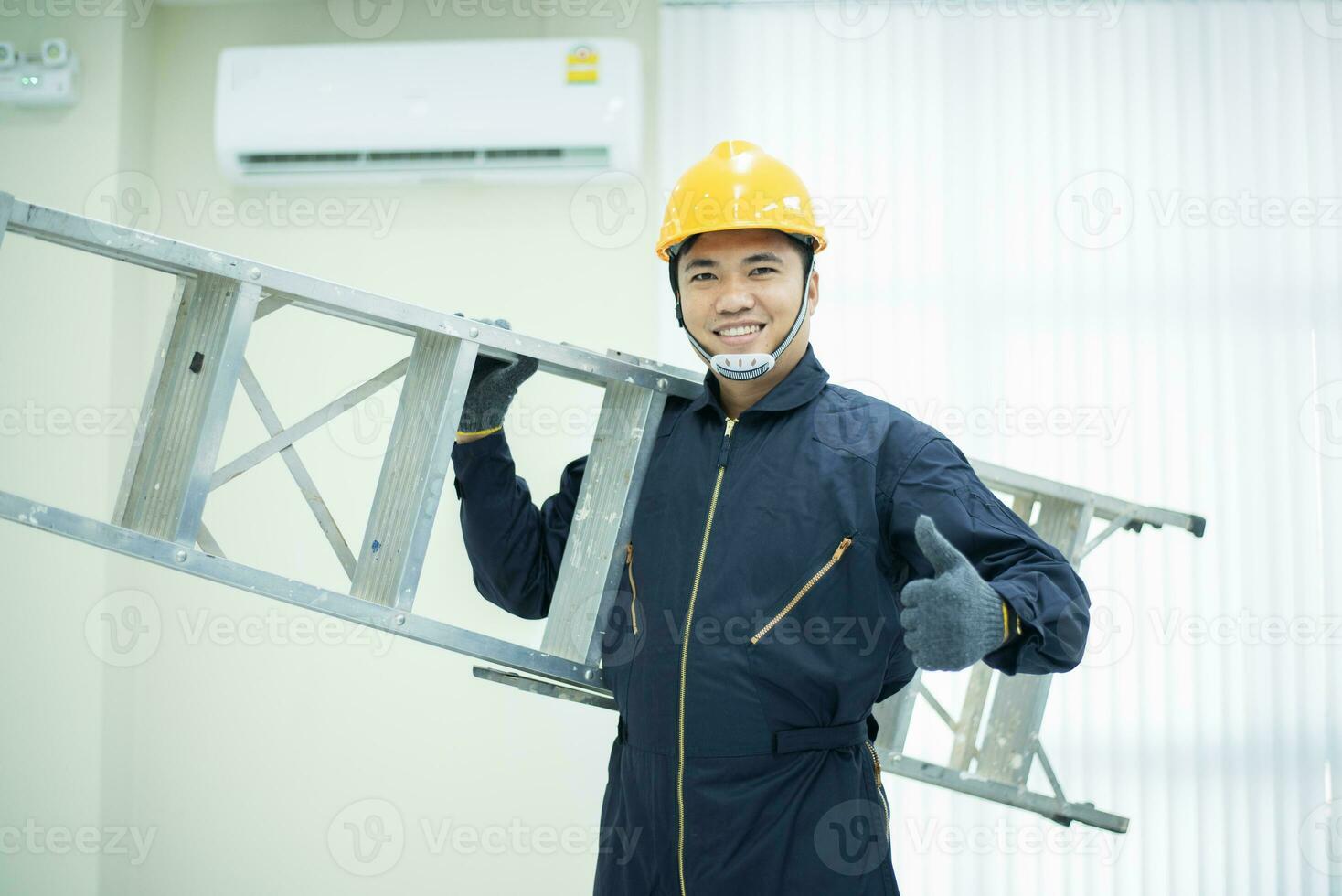 ein asiatisch jung Techniker Bedienung Mann tragen Blau Uniform prüfend, professionell Luft Conditioner Installateur Aufrechterhaltung modern Innen- Luft Conditioner Raum zum Text foto