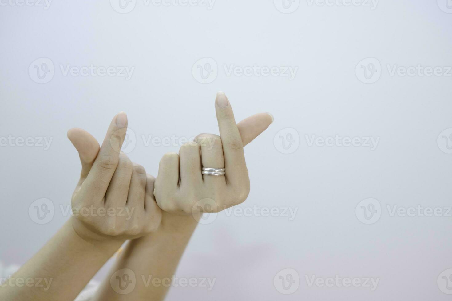 weiblich zwei Hand zeigen klein Herz auf ein Weiß isoliert Hintergrund, Nahansicht Mini Herz Zeichen durch Frauen Hand foto