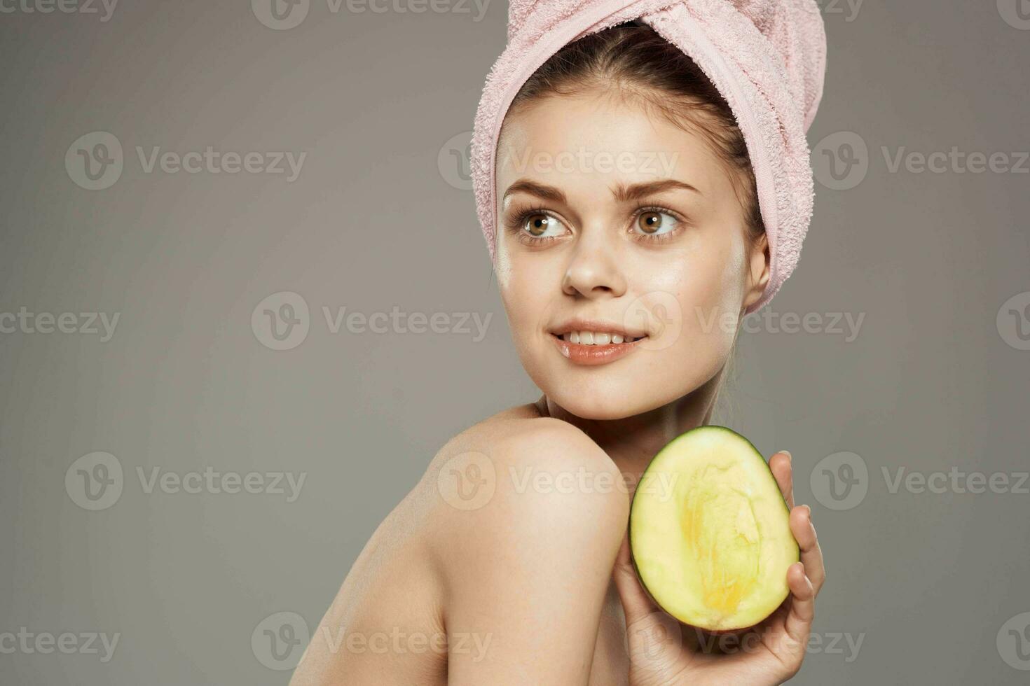 lächelnd Frau mit nackt Schultern mit Handtuch auf Kopf Mango im Hand abgeschnitten Aussicht foto
