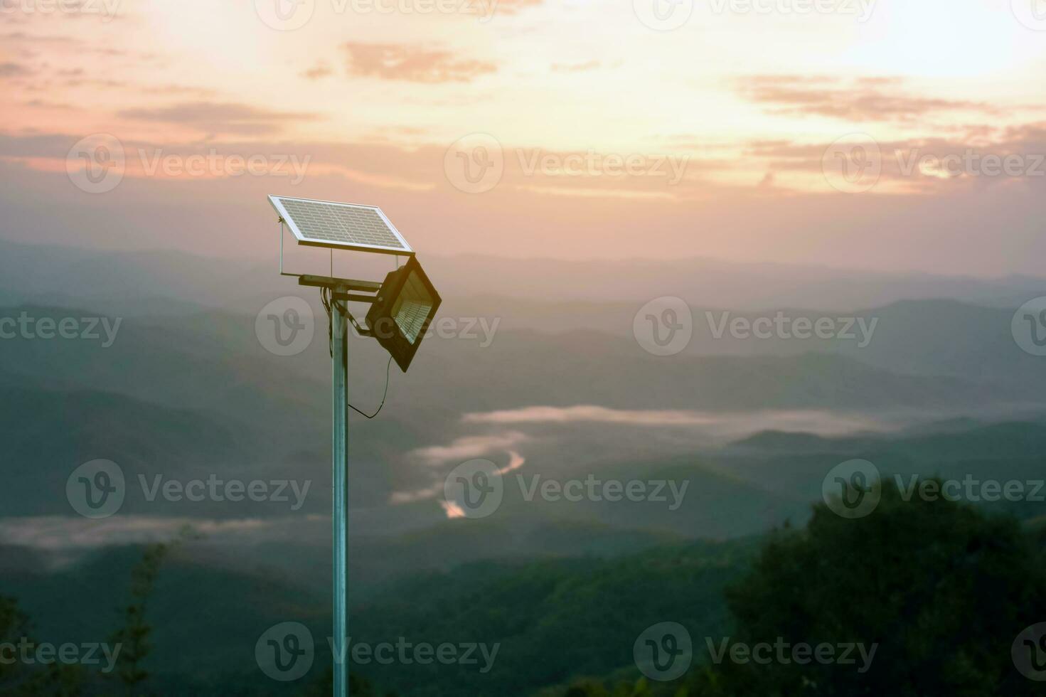 Mini Photovoltaik oder Solar- Zelle Panel Eingerichtet auf Metall Pole mit hd Scheinwerfer zu Geschäft und verwenden das Leistung von das Sonnenlicht beim Nacht um Haus auf das Berg, verschwommen Sonnenuntergang Berg Hintergrund. foto