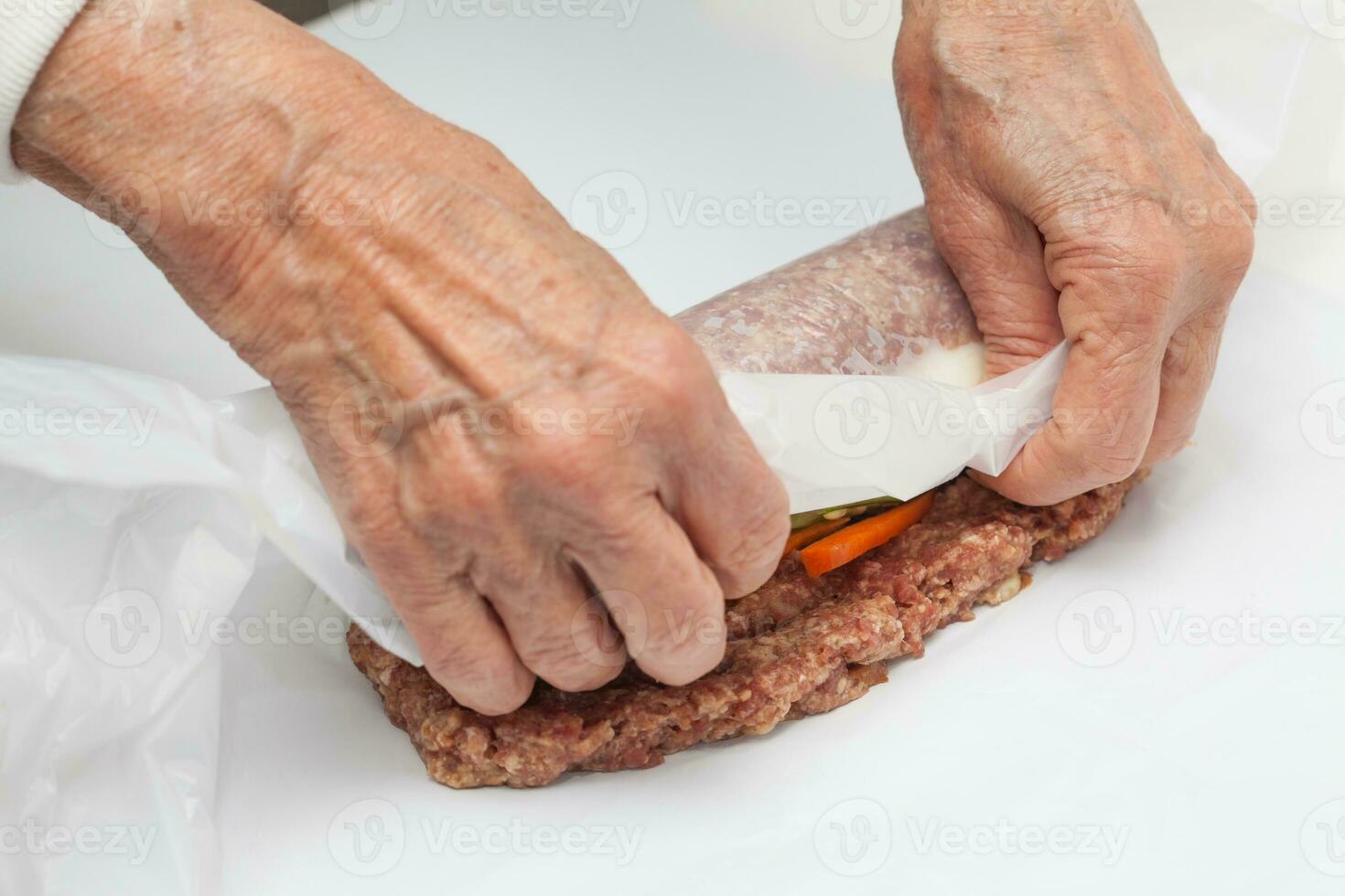 Vorbereitung von ein gebacken Ei und Gemüse ausgestopft Hackbraten bedeckt mit Speck. Fleisch rollen foto