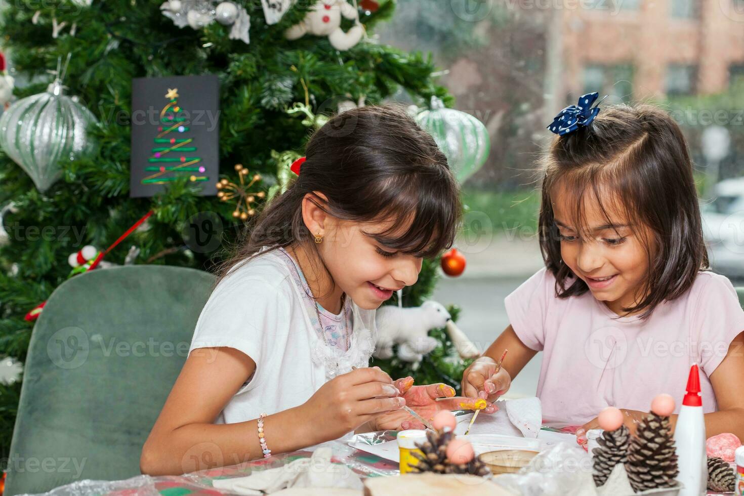 zwei wenig Schwestern haben Spaß während Herstellung Weihnachten Geburt Kunsthandwerk mit beim Zuhause - - echt Familie foto