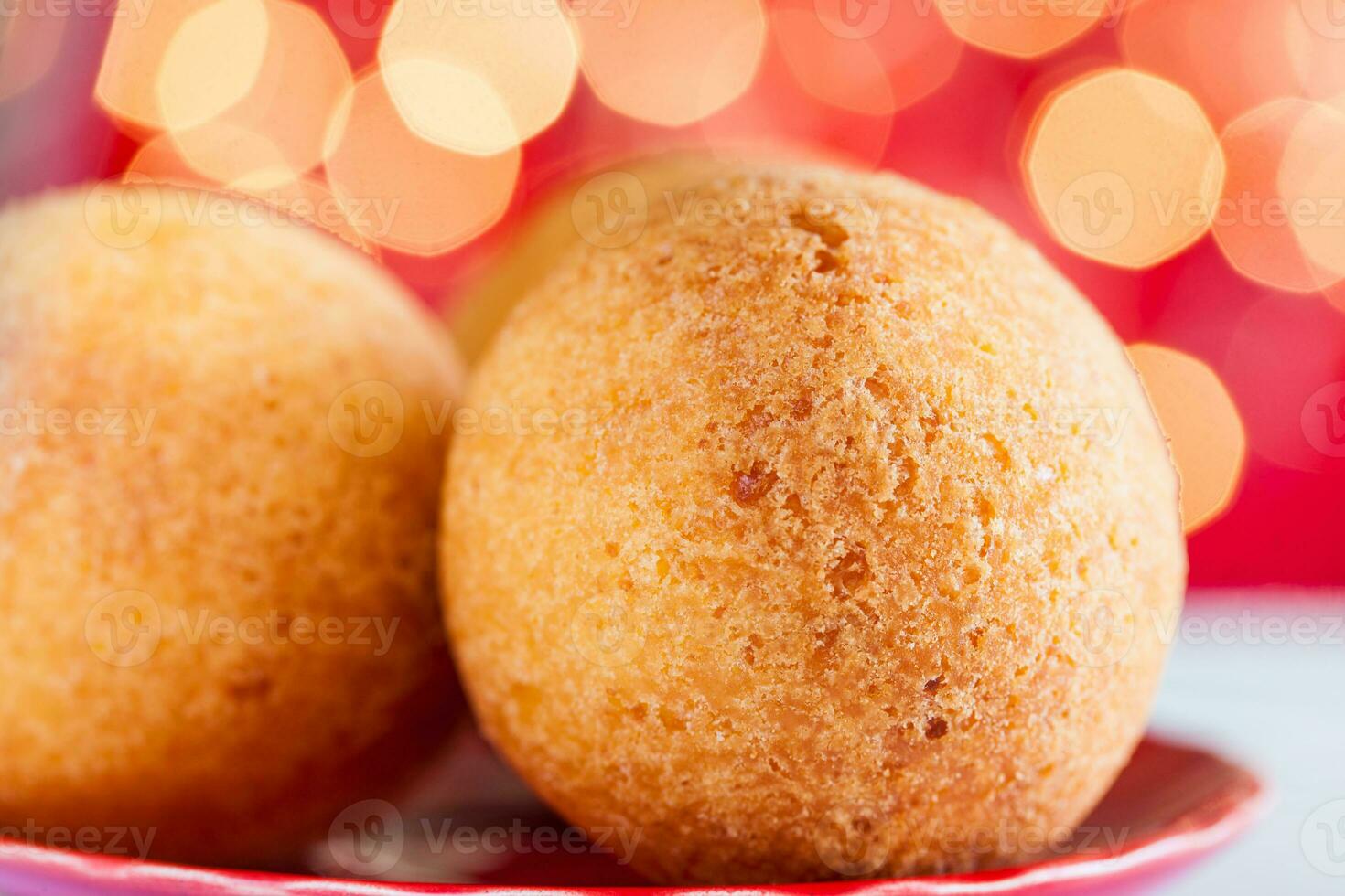 traditionell kolumbianisch Bunuelos. tief gebraten Käse Brot auf Weihnachten rot Hintergrund foto