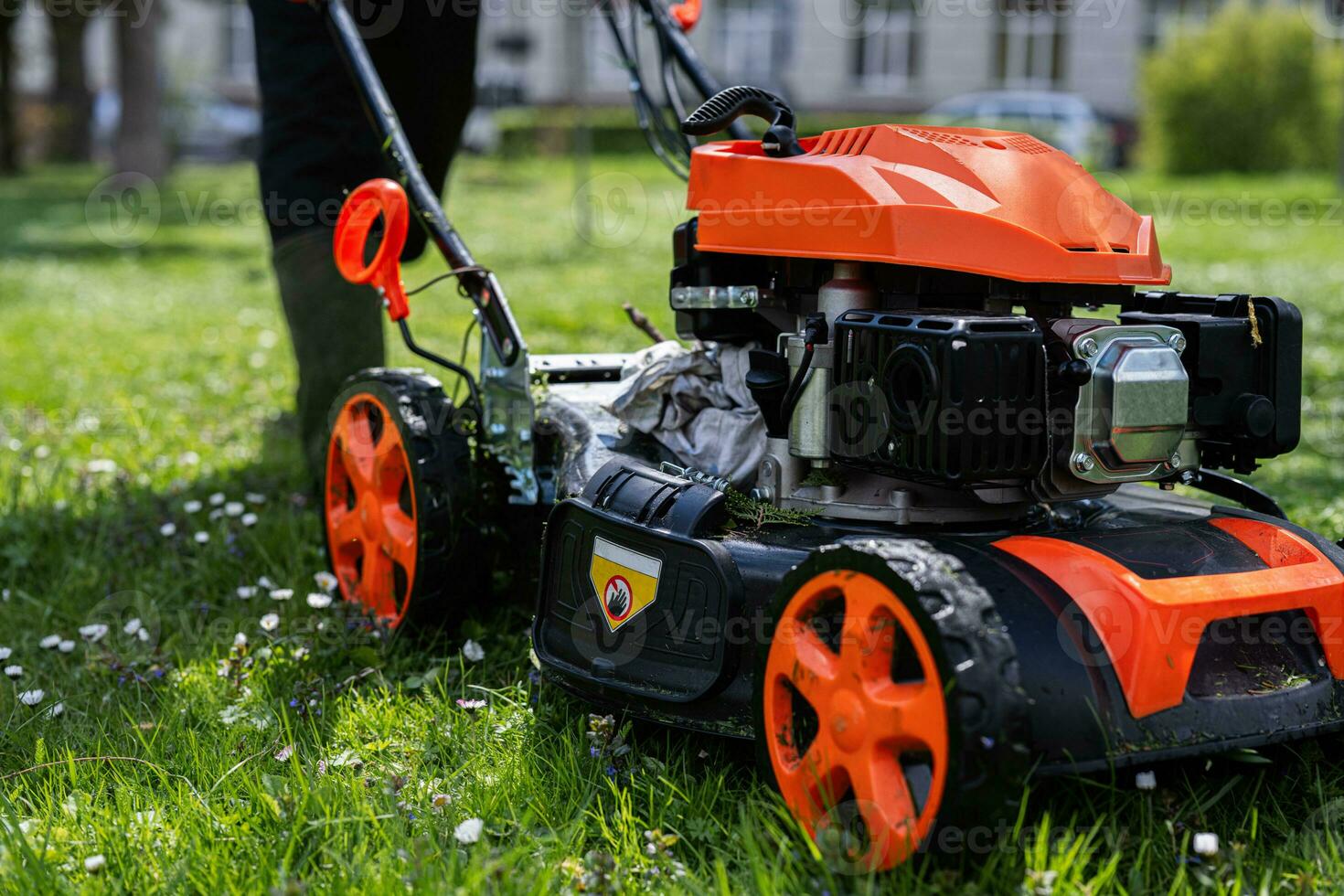 gemeinschaftlich Dienstleistungen Gärtner Arbeiter Mann mit Rasen Mäher zum Gras Schneiden im Stadt Park. foto