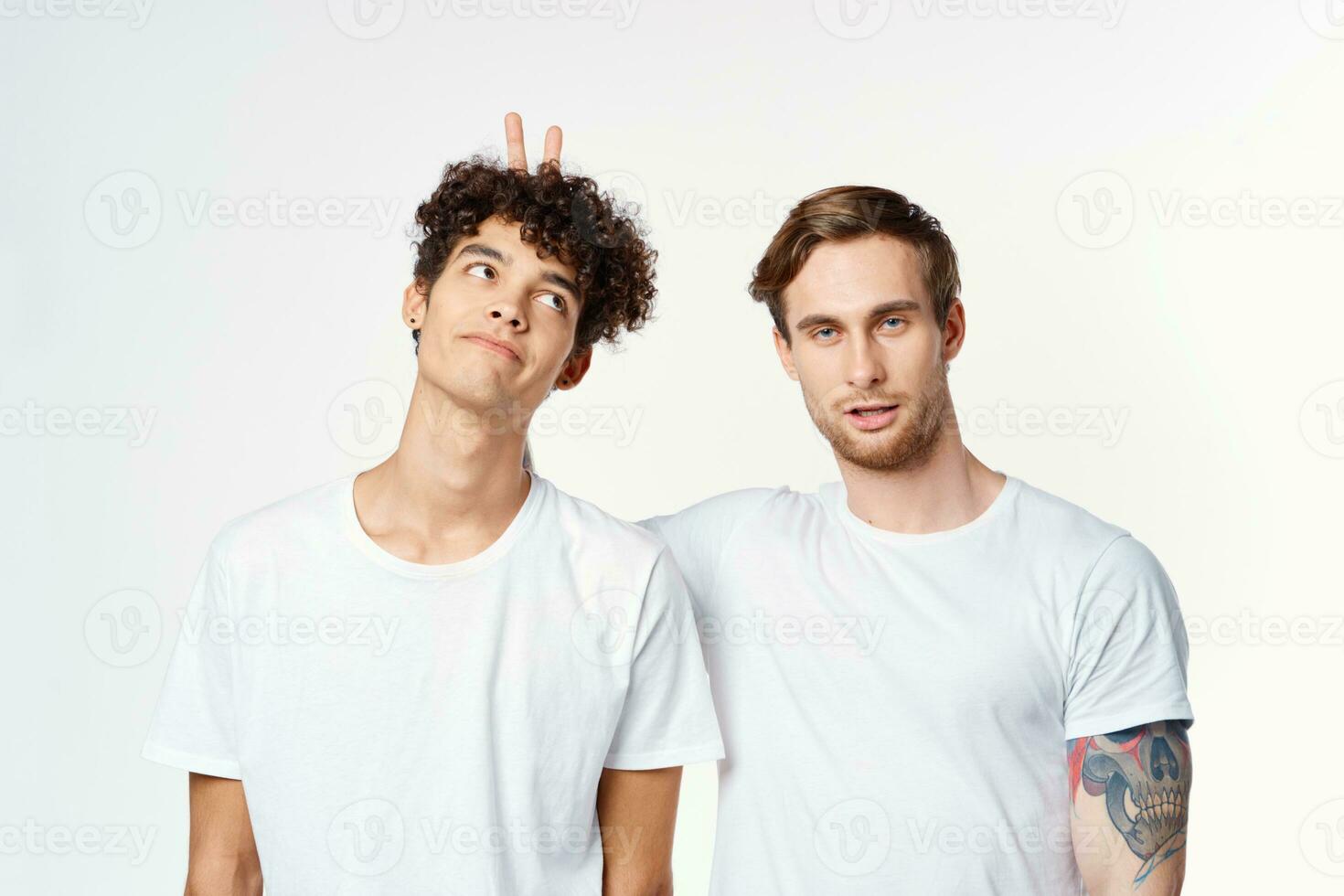 zwei Männer im Weiß T-Shirts gestikulieren mit ihr Hände Freundschaft Studio foto