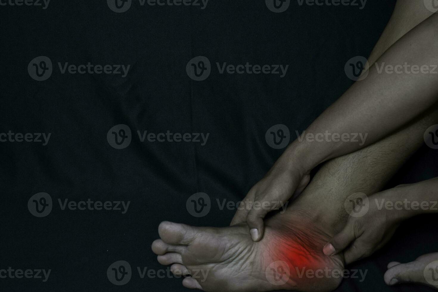 asiatisch Mann halten seine Fuß. er fühlt sich Schmerzen Fuß Hacke mit schwarz Hintergrund. plantar Faszilitis. medizinisch oder Gesundheitswesen Konzept foto