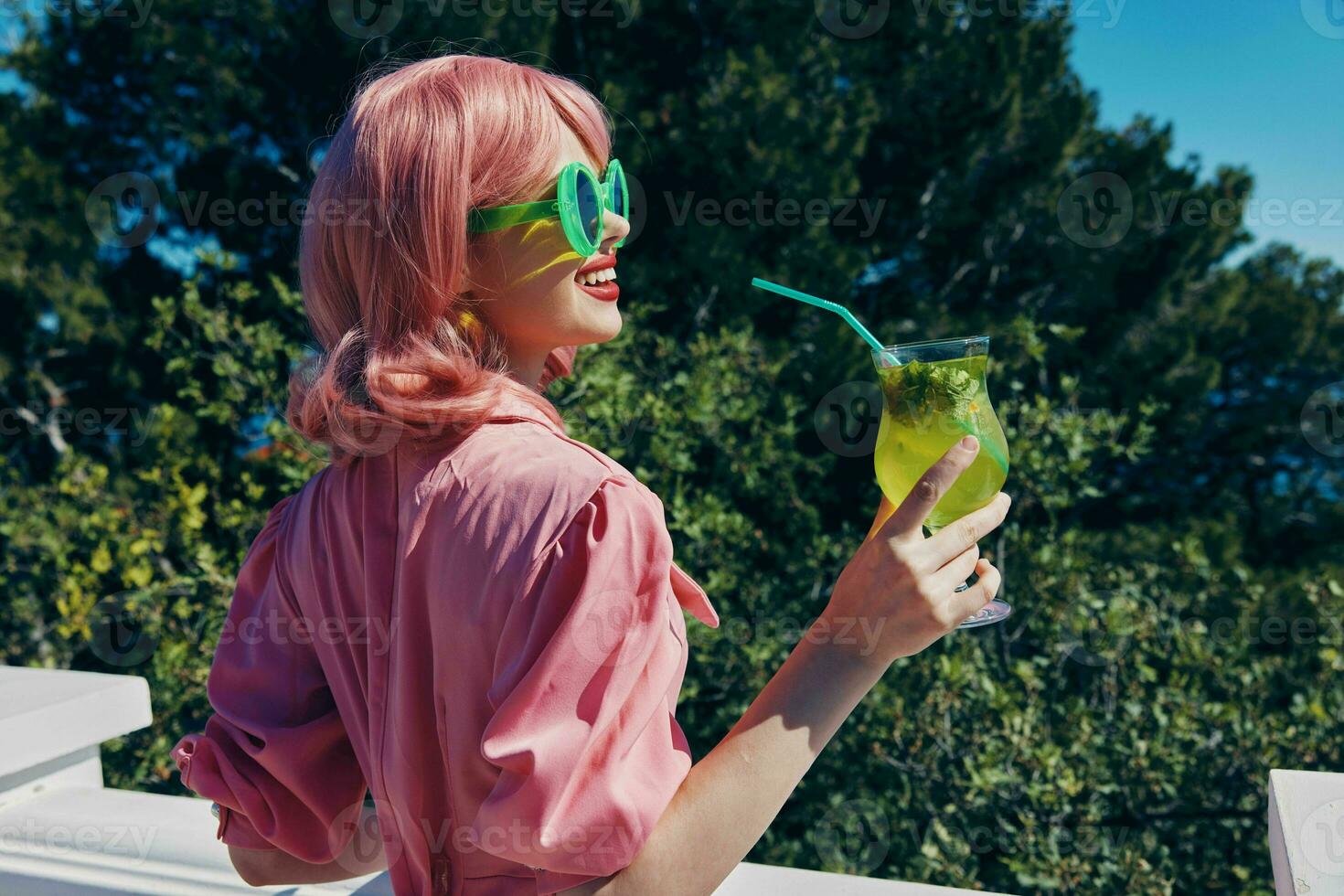 modisch Frau im Grün Sonnenbrille mit Cocktail im Sommer- draußen Sommer- Tag foto