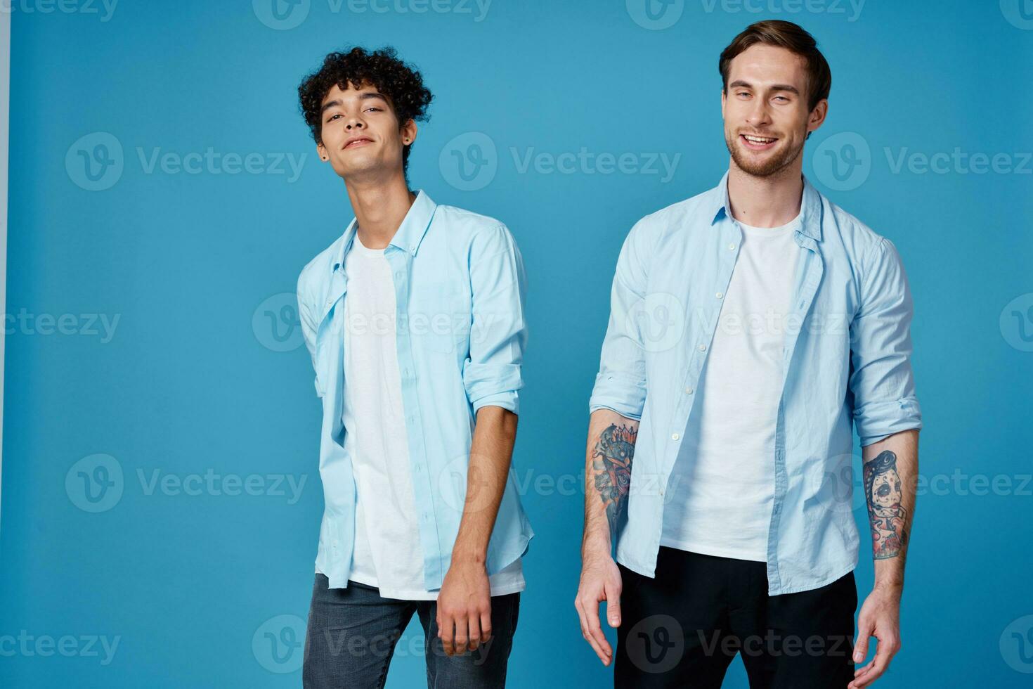 zwei freunde im ein aufgeknöpft Hemd und im Weiß T-Shirts auf ein Blau Hintergrund gestikulieren mit Hände abgeschnitten Aussicht Party foto