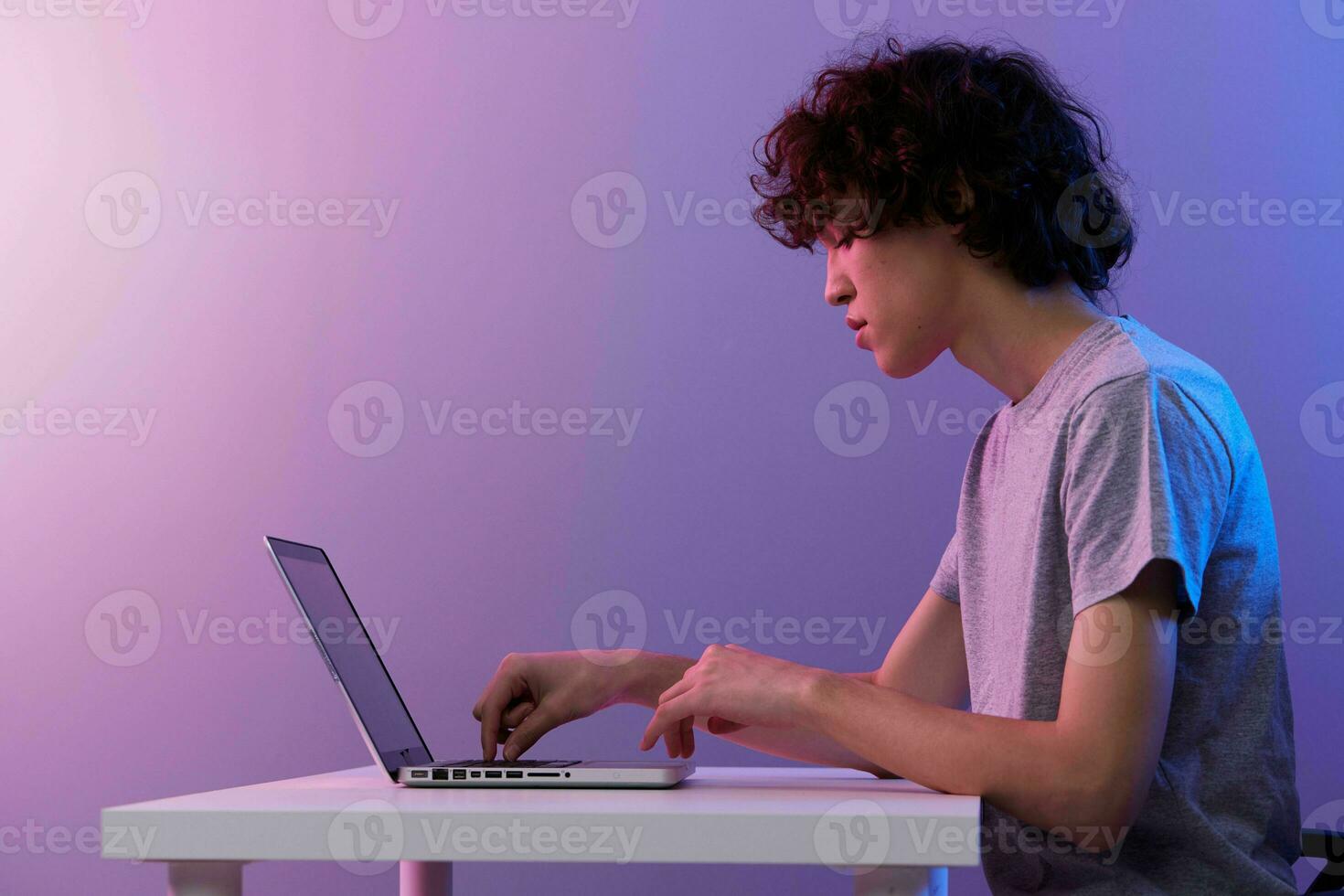 Mann Cyberspace spielen mit im Vorderseite von ein Laptop violett Hintergrund foto