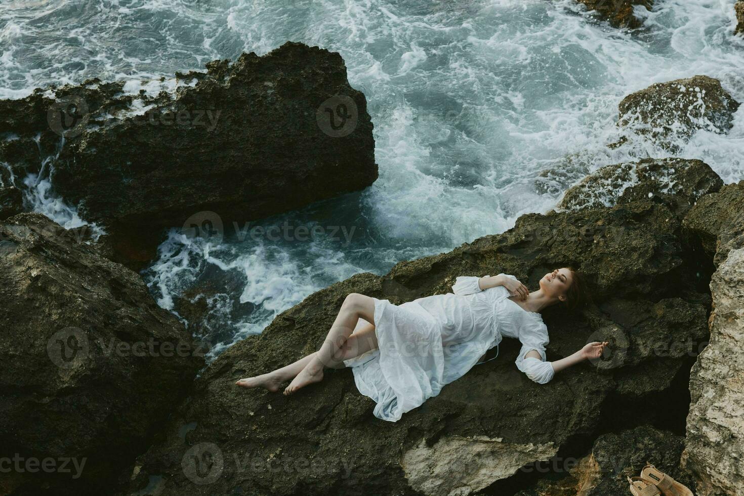 schön Braut im Weiß Hochzeit Kleid auf Meer Ufer nass Haar Aussicht von über foto