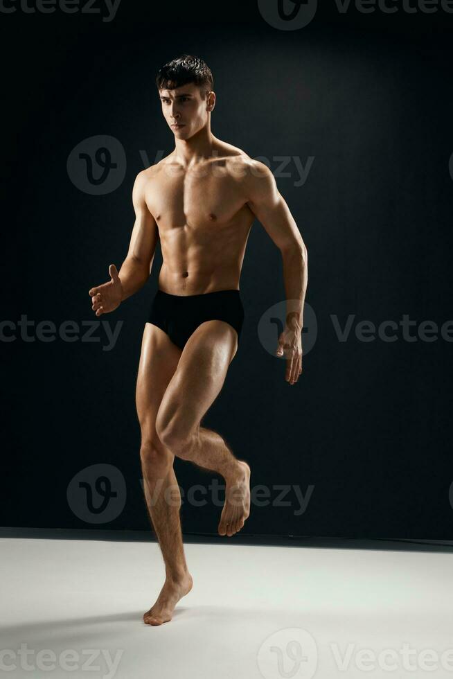 sportlich Mann mit muskulös Körper posieren im dunkel Höschen foto