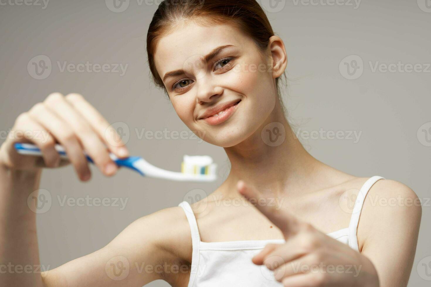 heiter Frau mit ein Zahnbürste im Hand Morgen Hygiene Licht Hintergrund foto