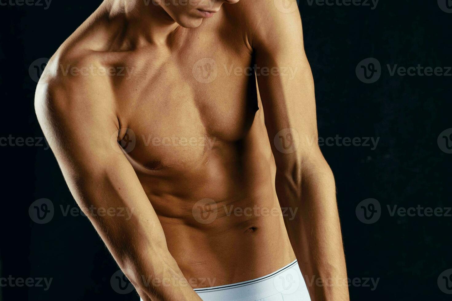 sportlich Mann im Weiß kurze Hose gepumpt oben Torso trainieren abgeschnitten Aussicht Studio foto