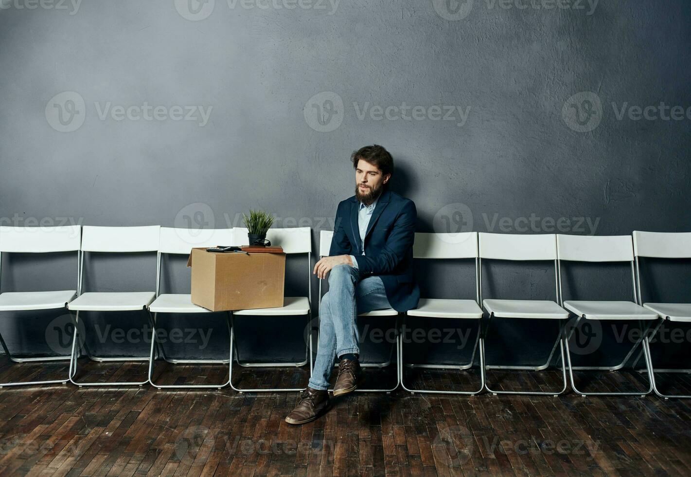 Mann sitzt auf ein Stuhl Box mit Dinge entlassen Unzufriedenheit Depression foto