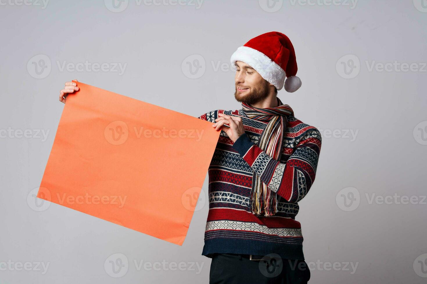 heiter Mann im ein Weihnachten Hut mit rot Attrappe, Lehrmodell, Simulation Poster Licht Hintergrund foto