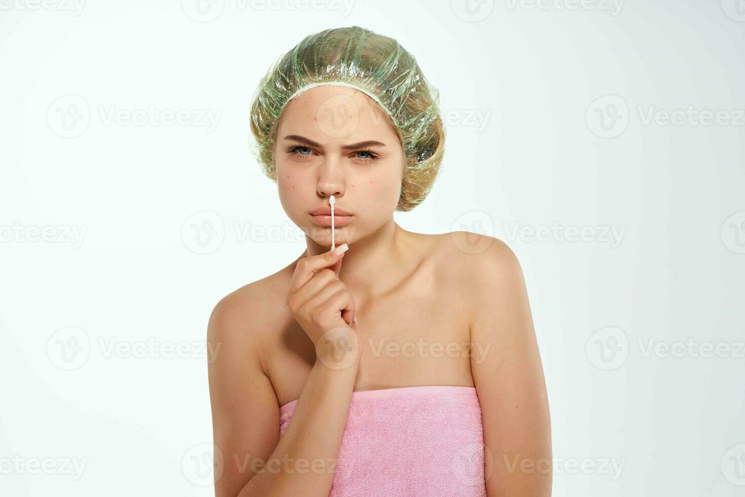 Frau mit nackt Schultern Tücher ihr Gesicht mit ein Baumwolle Tupfer Haut Probleme foto