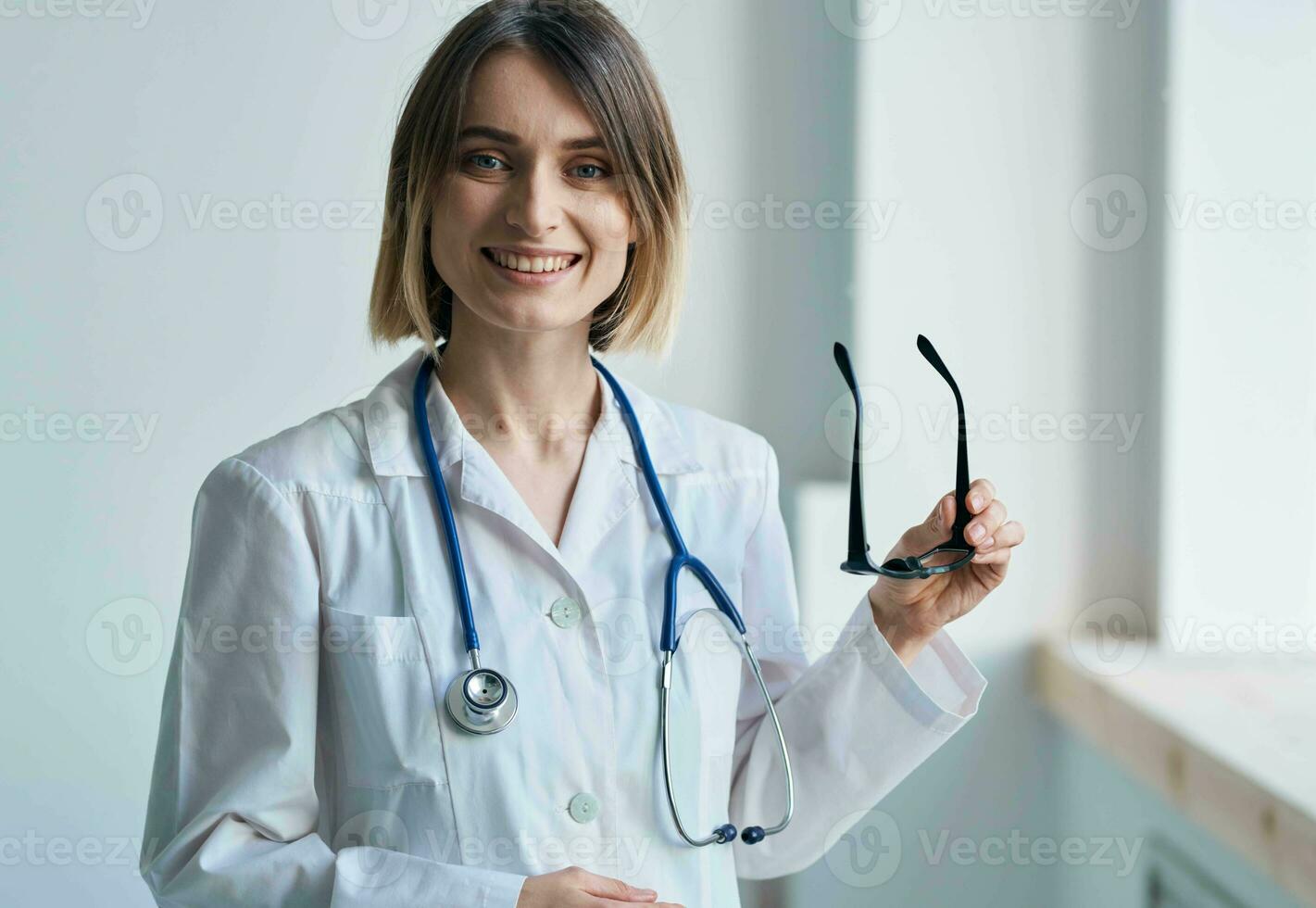 Fachmann Arzt Frau halten Brille im ihr Hand und Stethoskop um ihr Hals foto