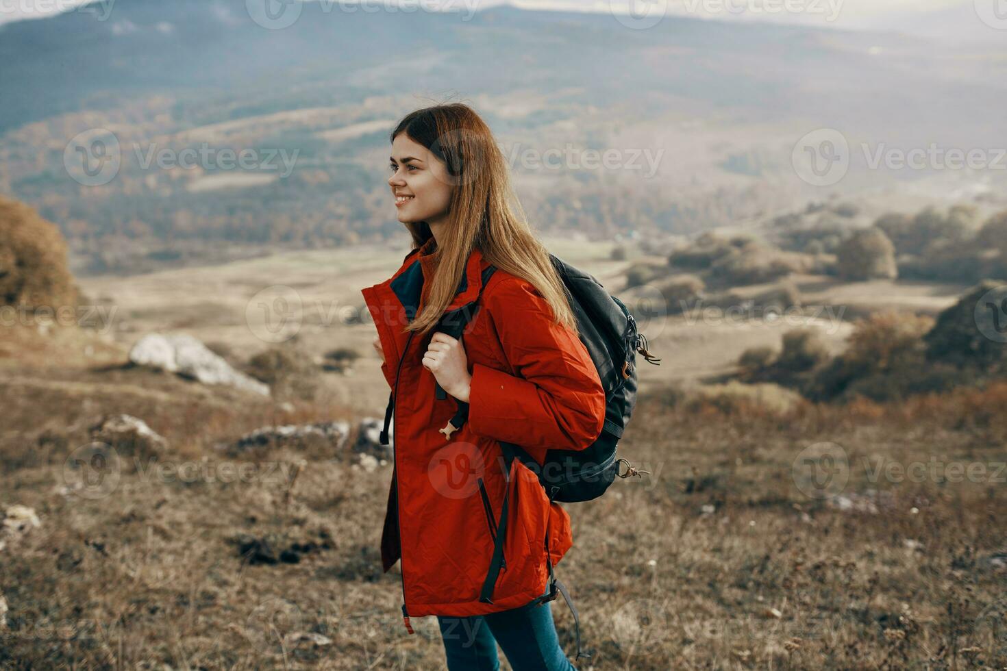 rothaarig Frau im Jacke mit Rucksack Reise Wandern Berge frisch Luft foto