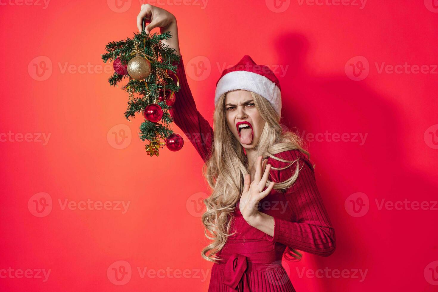 ziemlich Frau im Santa claus Kostüm halten ein Weihnachten Baum im ihr Hände Freude Rosa Hintergrund foto