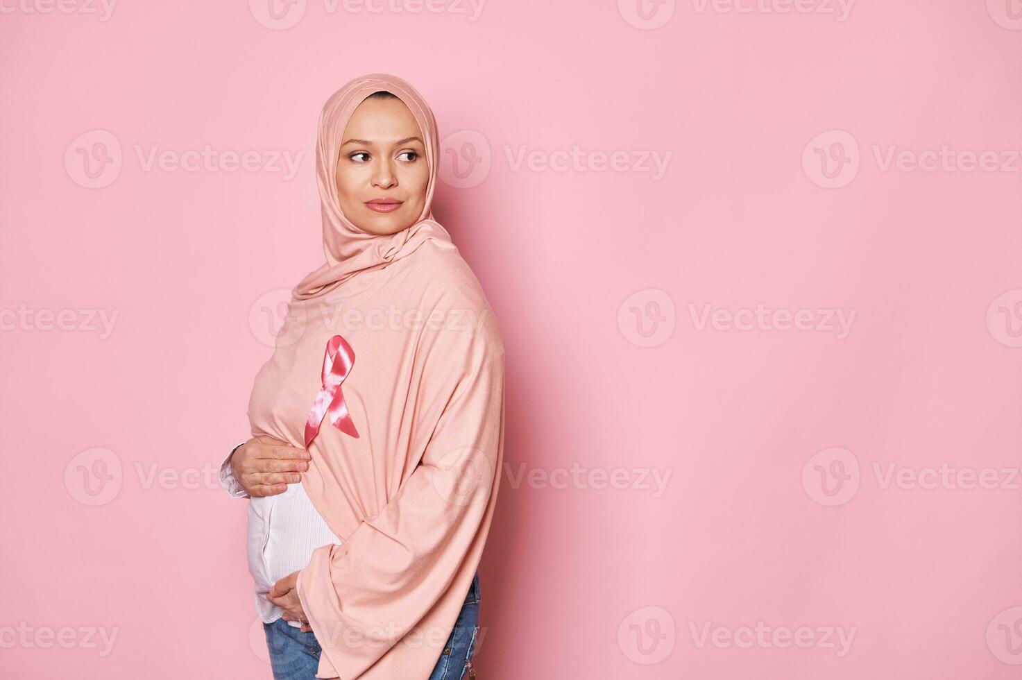 schwanger Muslim Frau tragen Rosa Band auf Kopftuch, zeigt an Unterstützung zum Brust Krebs Patienten. Oktober ist Bewusstsein Monat foto