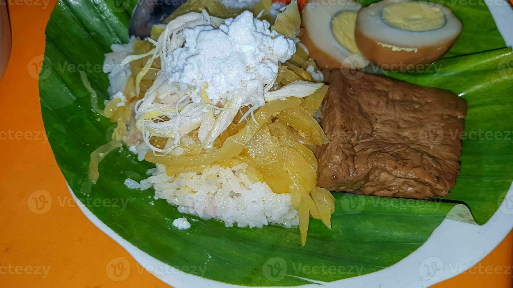 indonesisch Essen wenig Reis. ein traditionell javanisch Reis serviert mit Huhn, Tofu, Tempeh, Gemüse, Chili und breit Bohnen foto