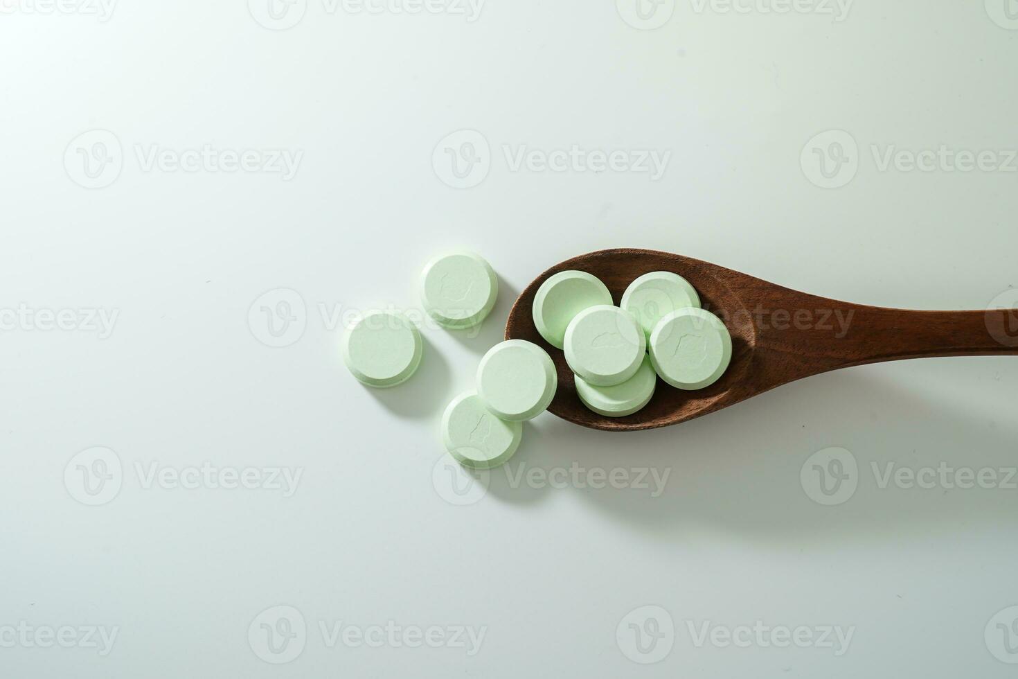 Gruppe von Medizin Tabletten und Antibiotika, Weiß medizinisch Tablets, Licht Grün, mit hölzern Löffel, mit Kopieren Raum. foto