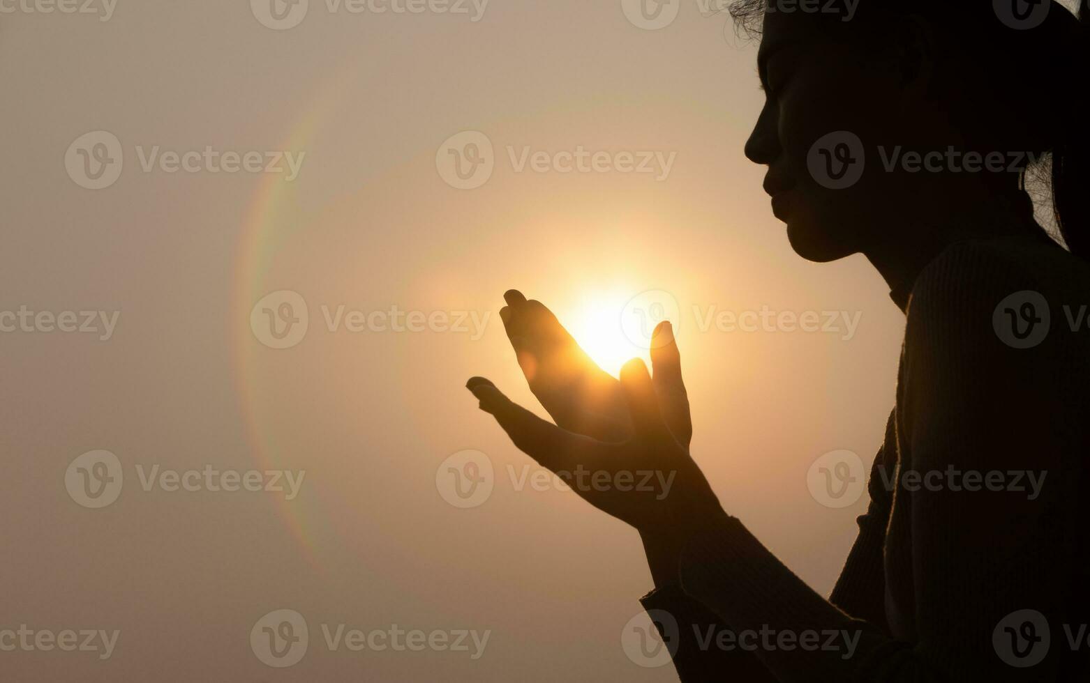 Silhouette von treu Frau beten beim Sonnenuntergang wie Konzept zum Religion, Glaube, Gebet und Spiritualität. foto