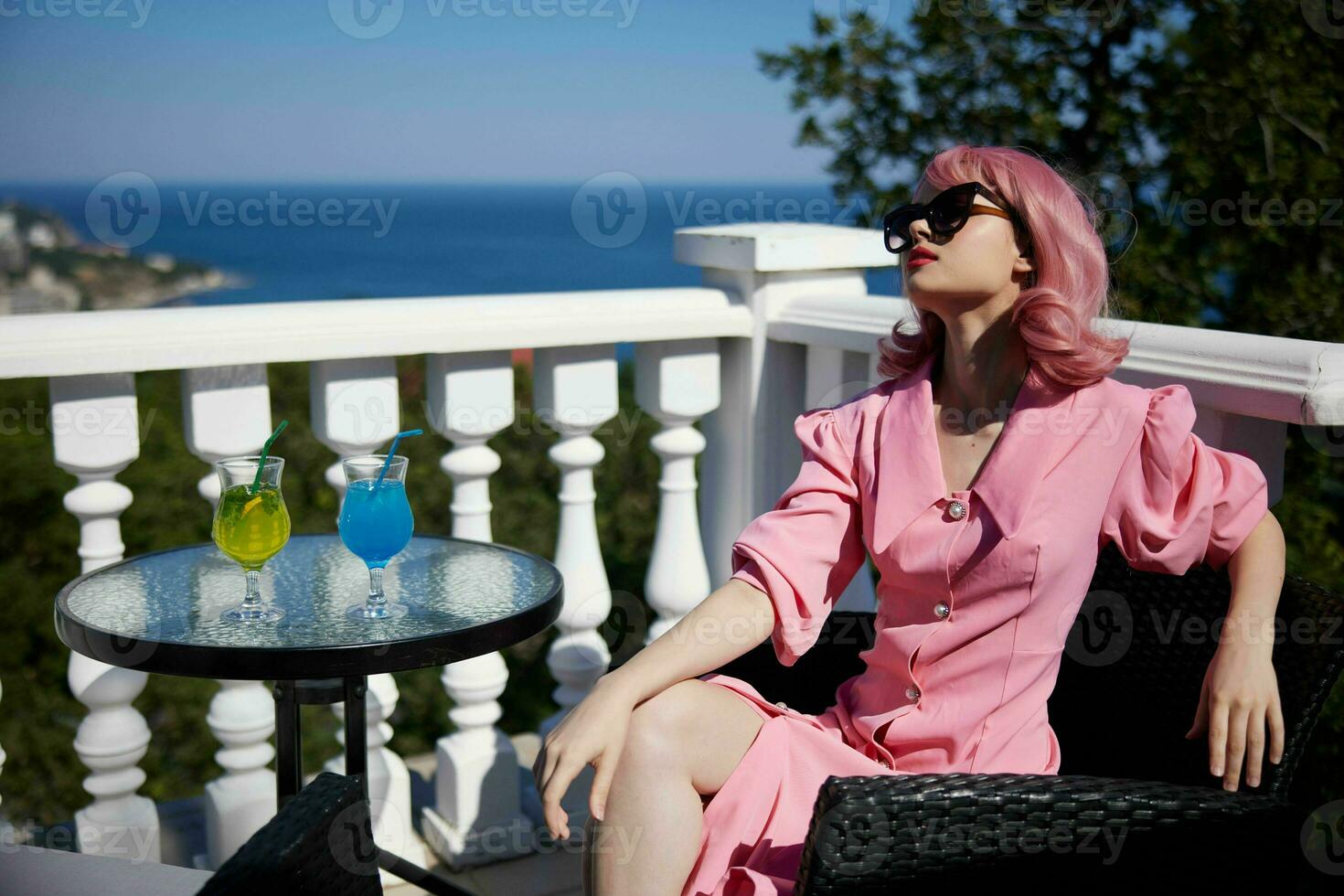 attraktiv Frau im Sonnenbrille draußen auf das Terrasse Cocktail entspannend unverändert foto