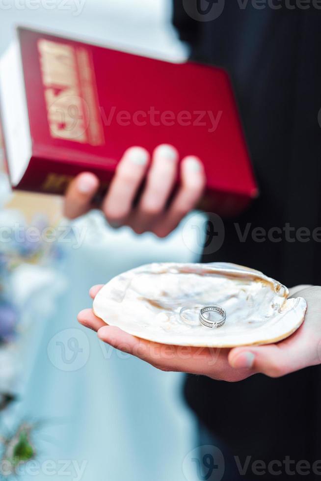 Hochzeitspaar auf dem Ozean mit einem Priester foto