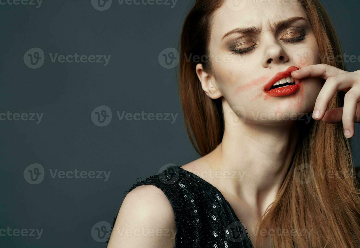 Frau im schwarz Kleid berühren Gesicht mit Hände und Lippenstift Stress Reizbarkeit foto