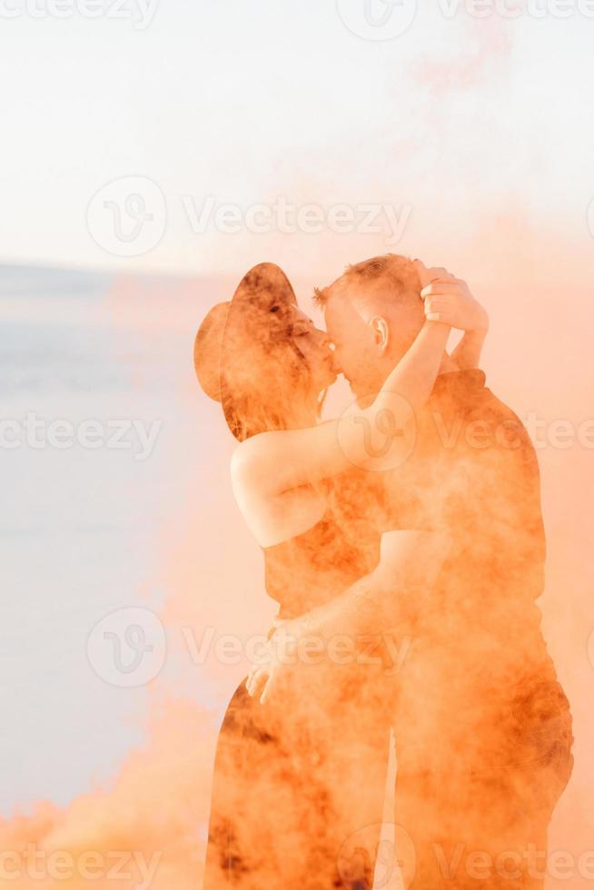 Mann und ein Mädchen in schwarzer Kleidung umarmen sich und rennen auf dem weißen Sand foto