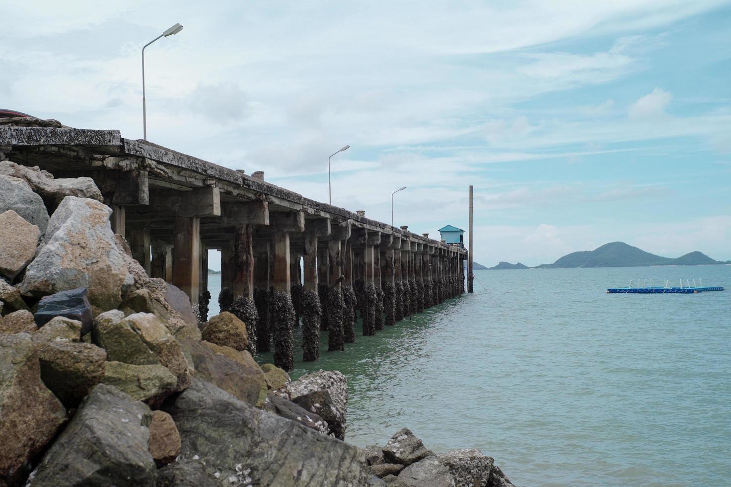 Betonstraße ins Meer mit Landschaft und Insel im Hintergrund. Seelandschaft und die Hafenstruktur ins Meer. foto