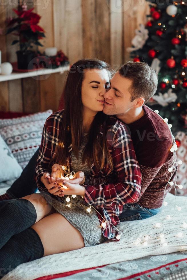 Mann und Mädchen feiern gemeinsam das neue Jahr und schenken sich gegenseitig Geschenke foto