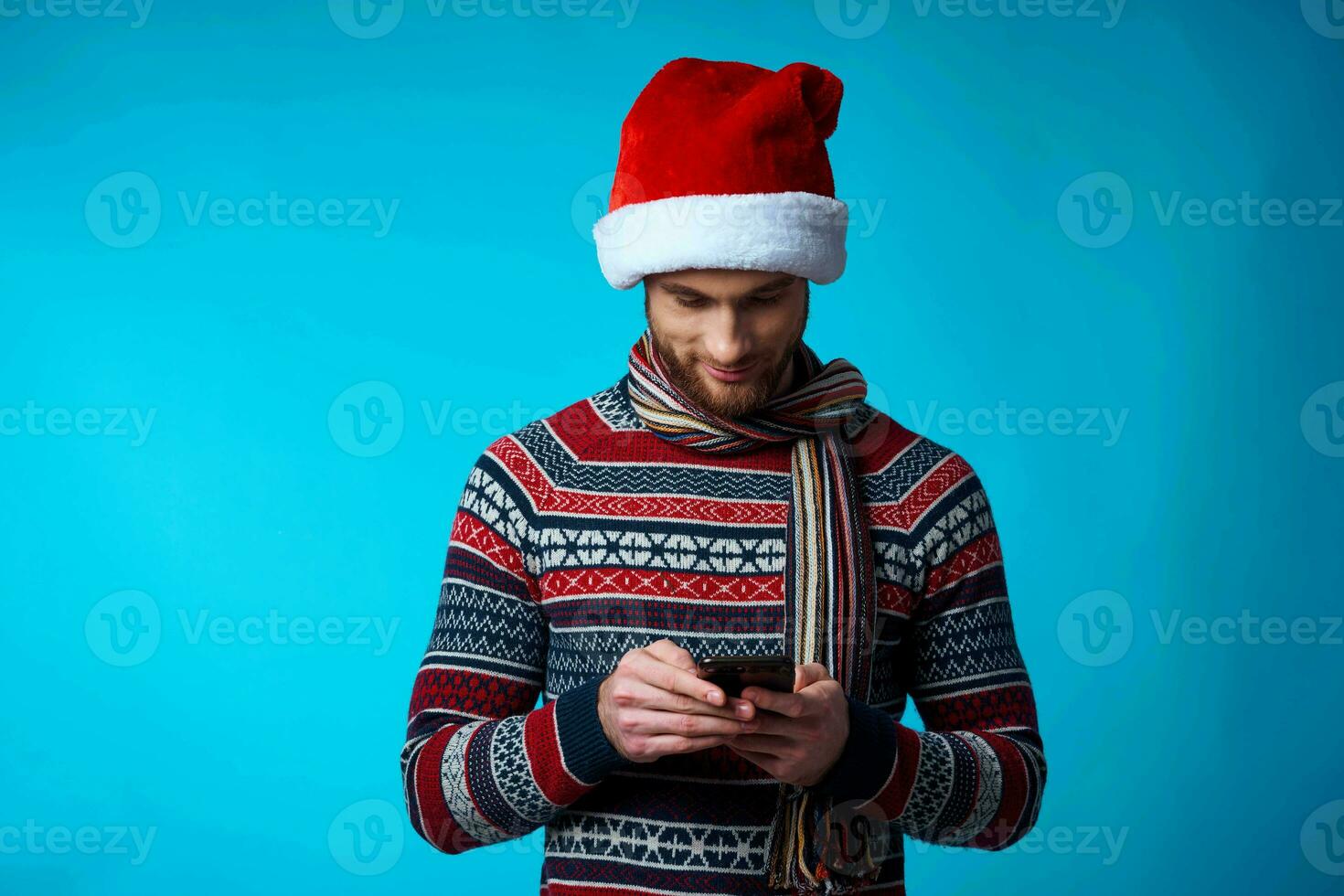 heiter Mann mit ein Telefon im Hand Urlaub Weihnachten Technologie Blau Hintergrund foto