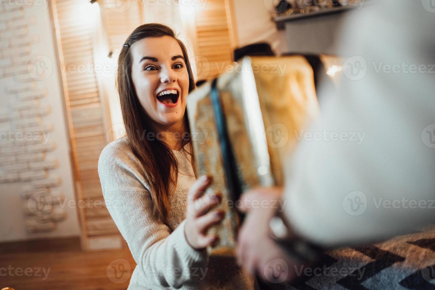 Mann und Mädchen feiern gemeinsam das neue Jahr und schenken sich gegenseitig Geschenke foto