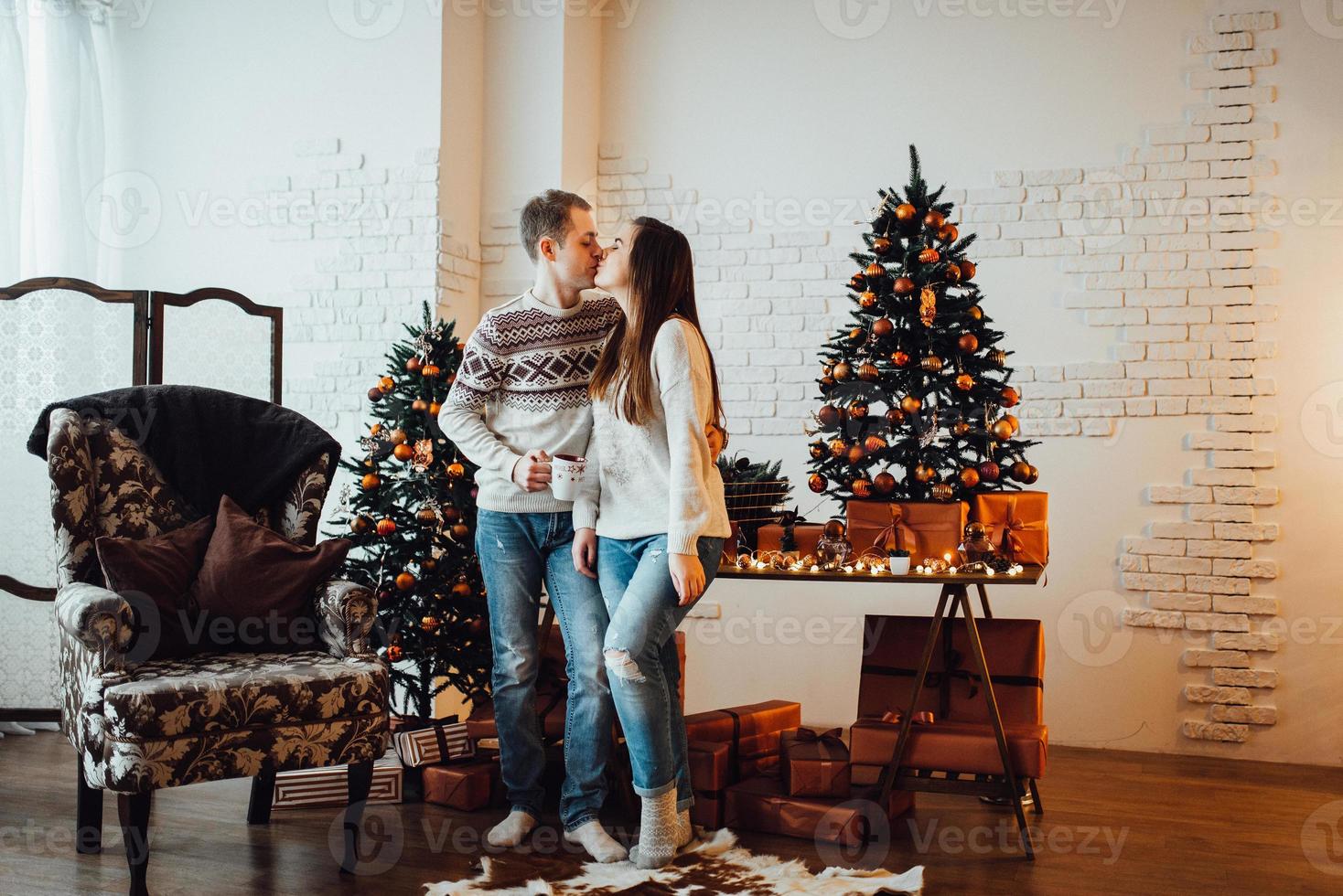 Mann und Mädchen feiern gemeinsam das neue Jahr und schenken sich gegenseitig Geschenke foto