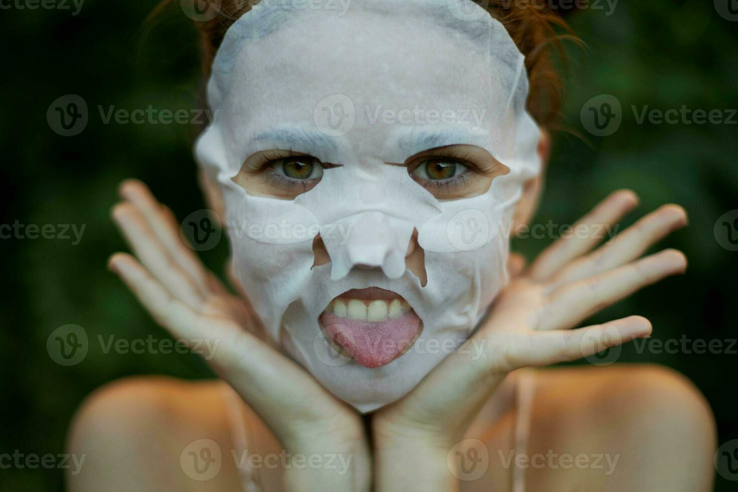 schön Frau Gesicht Maske zeigt an Zunge und hält Hände in der Nähe von Gesicht Dermatologie foto