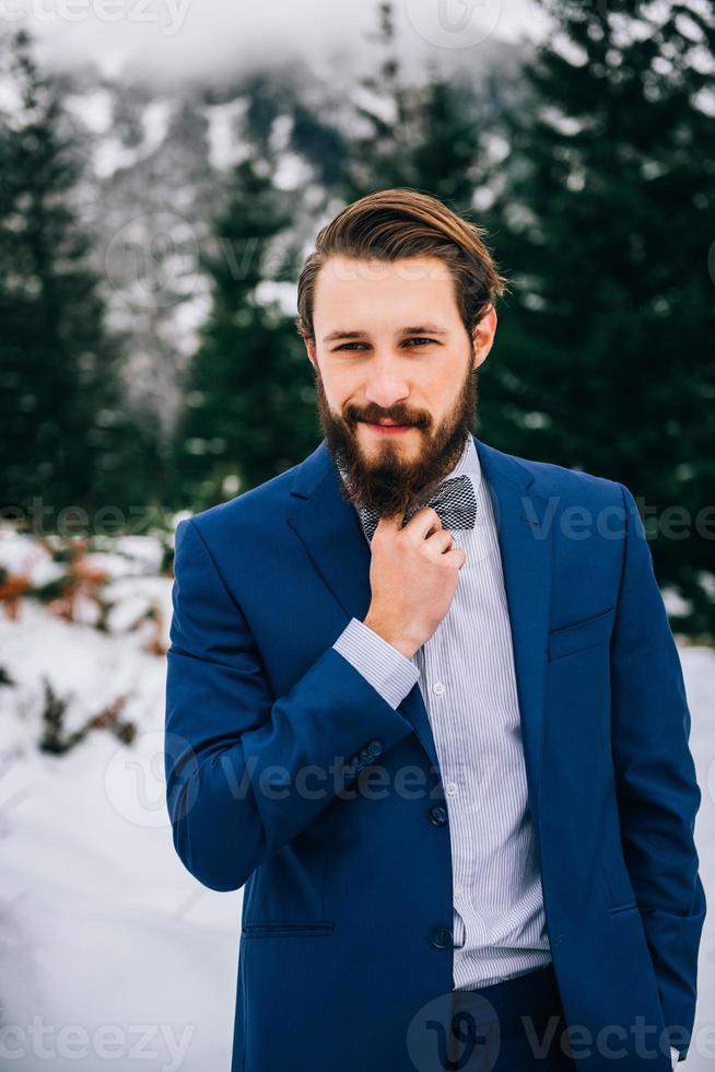 Bräutigam in einem blauen Anzug in den Bergen Karpaten foto