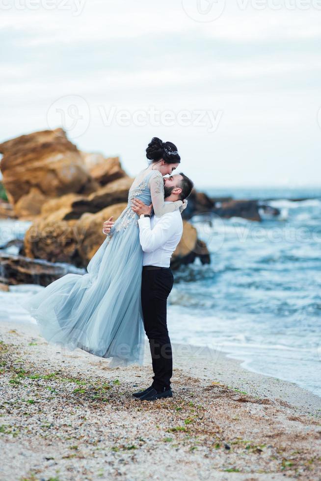 das gleiche Paar mit einer Braut in einem blauen Kleid zu Fuß foto