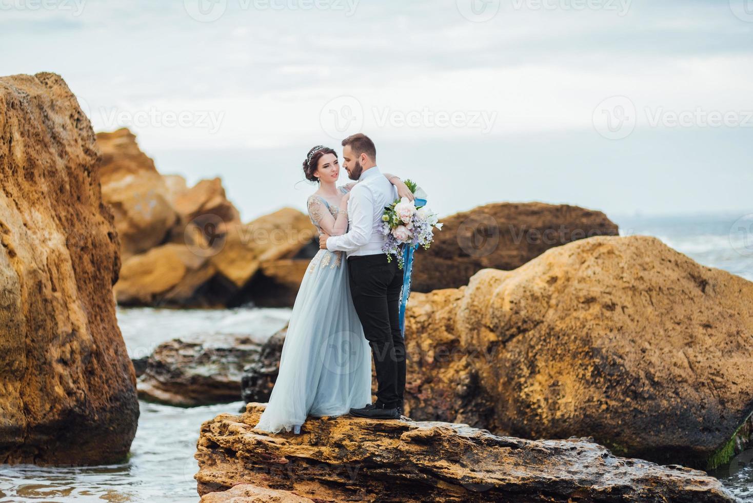 das gleiche Paar mit einer Braut in einem blauen Kleid zu Fuß foto