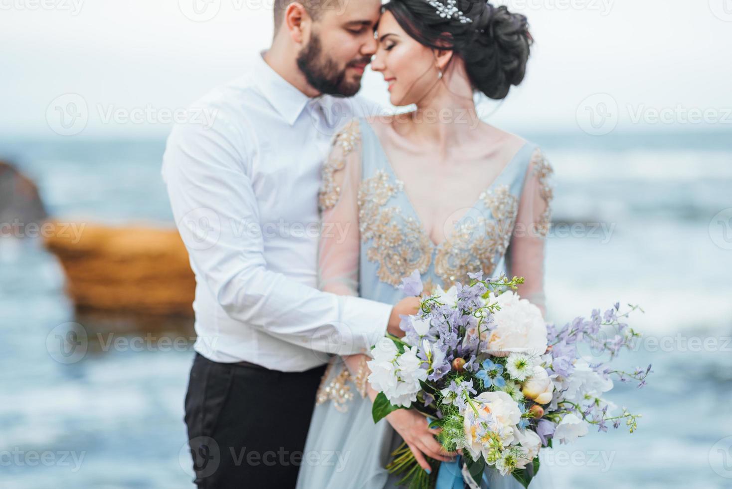 das gleiche Paar mit einer Braut in einem blauen Kleid zu Fuß foto